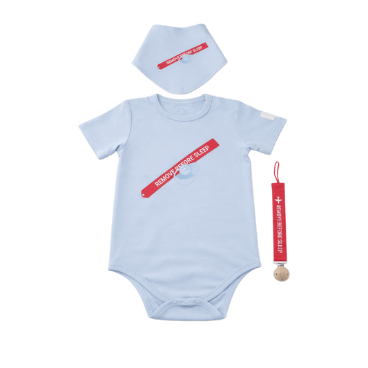 Baby onesie, bib, and teether set with 'Remove Before Sleep' text