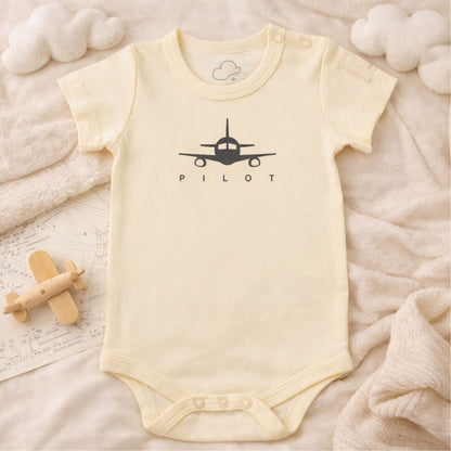 Beige short sleeve baby bodysuit with PILOT aviation print in lifestyle setting