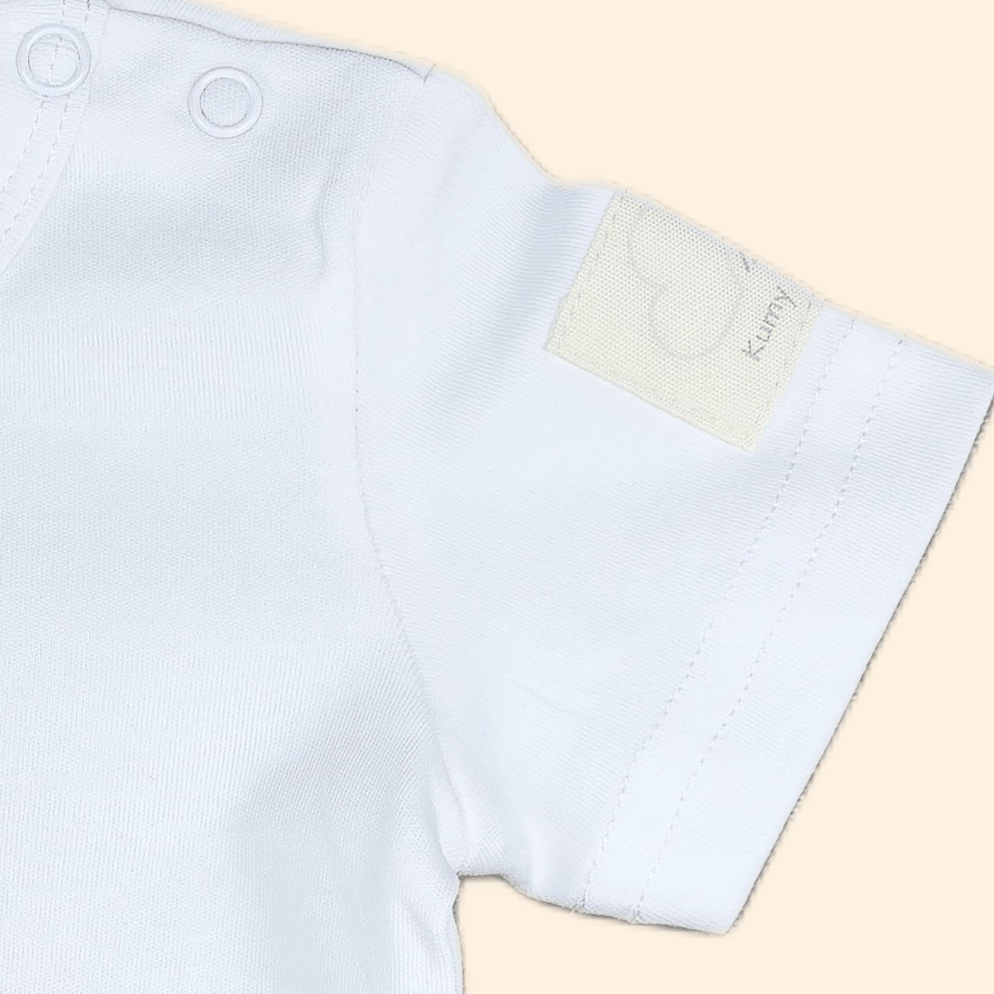 Ivory short sleeve baby bodysuit detail showing soft fabric and premium stitching