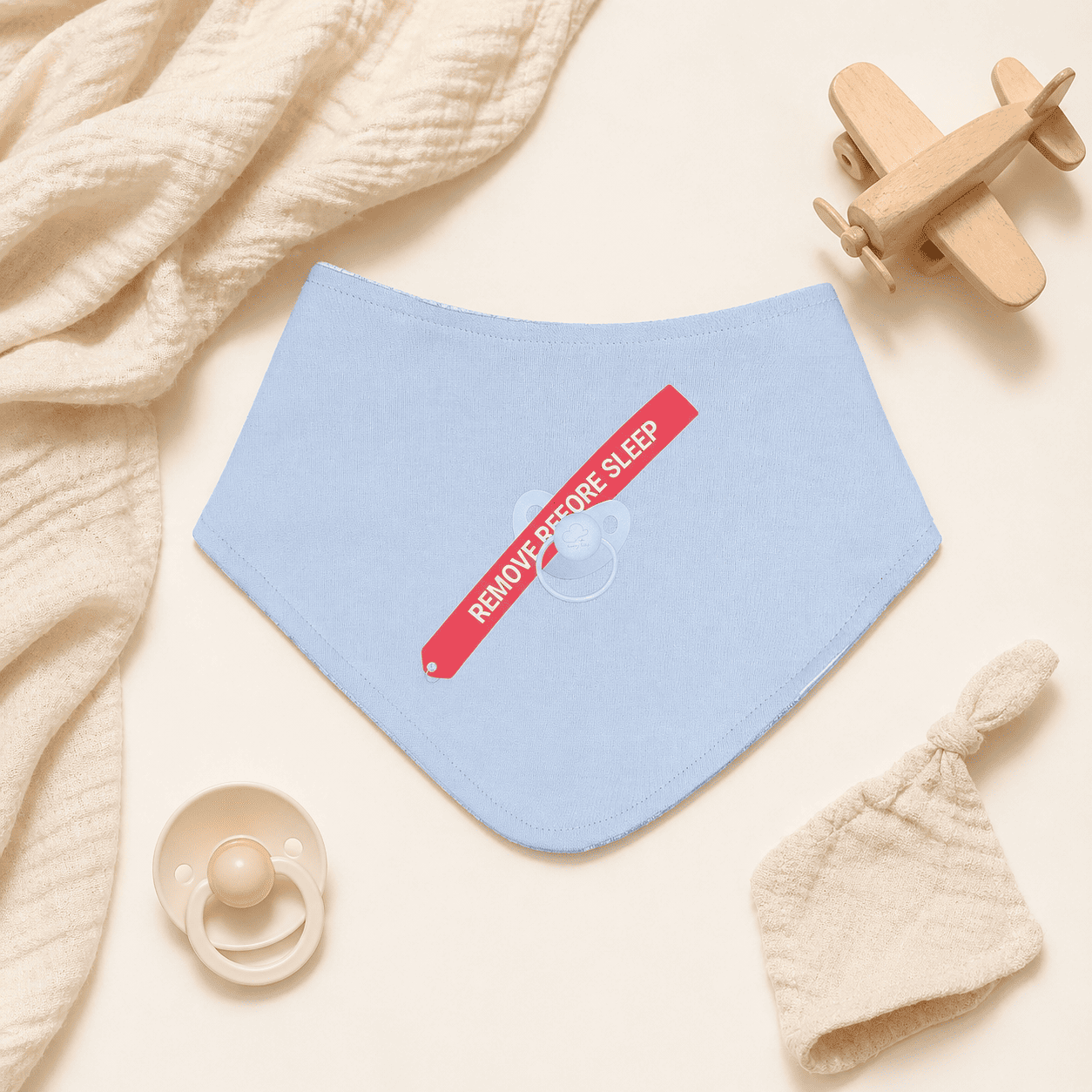Steel blue baby bib with aviation arrow print in nursery setting
